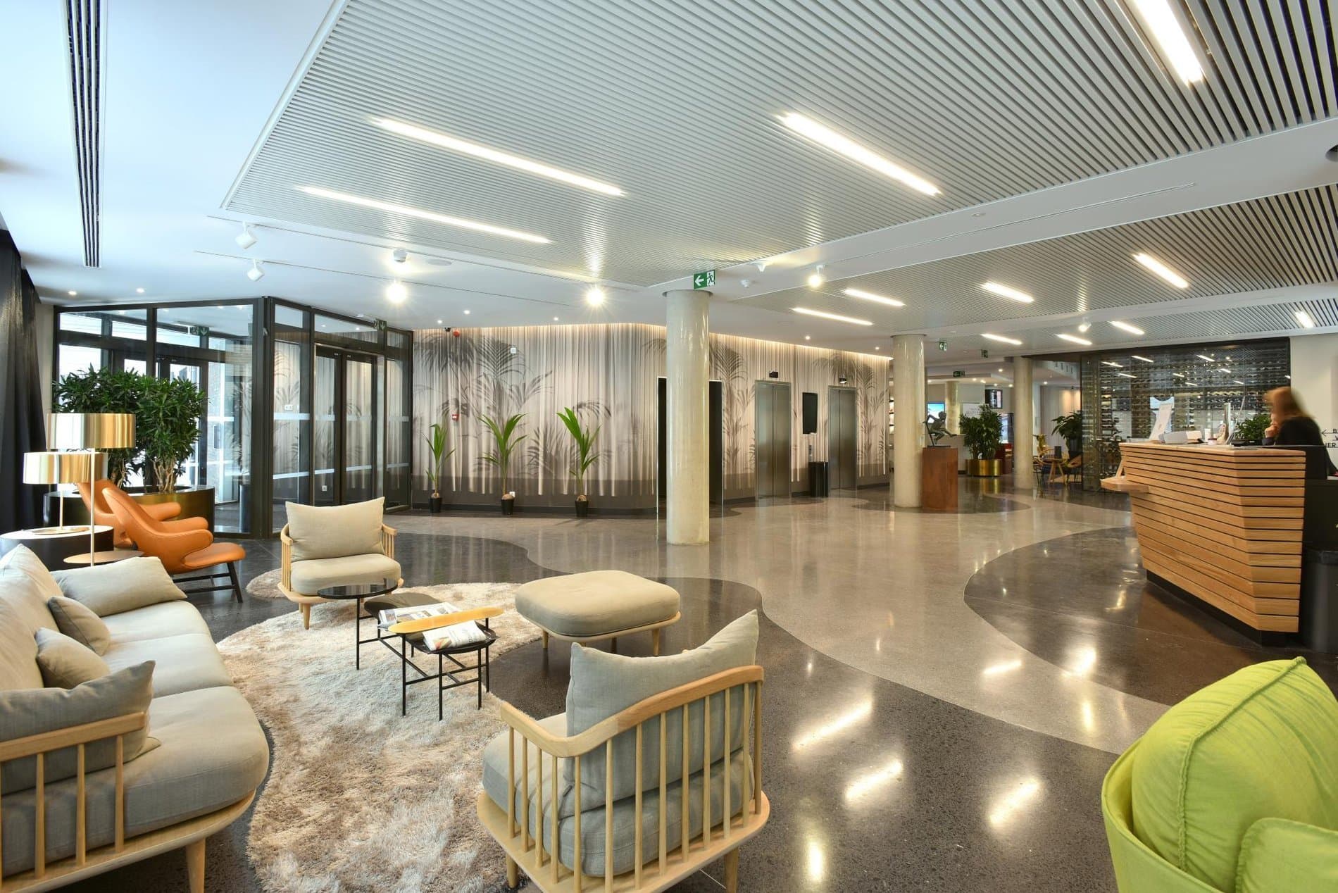 Modern hotel lobby with lounge seating, reception desk, and contemporary design elements throughout.