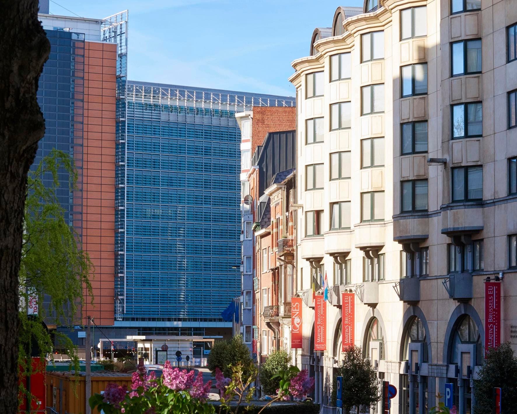 Urban neighborhood with historic cream-colored facades and modern glass building.