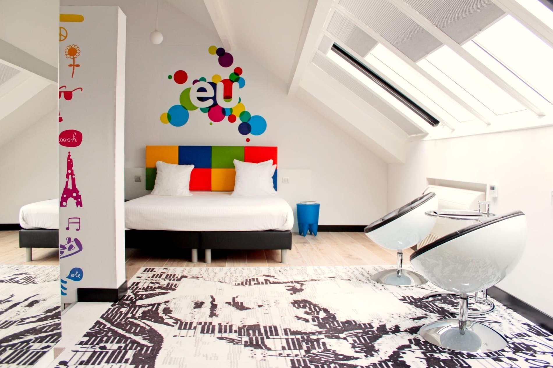 Modern bedroom suite with colorful headboard art and minimalist contemporary design elements.