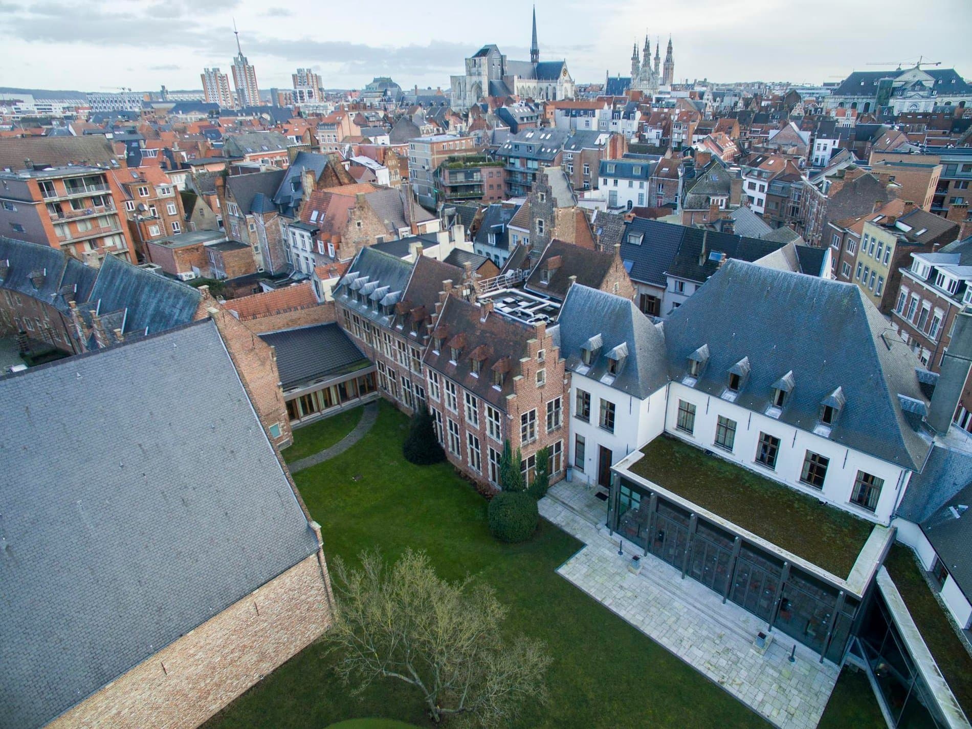 Historic European city courtyard with manicured gardens and surrounding residential architecture.