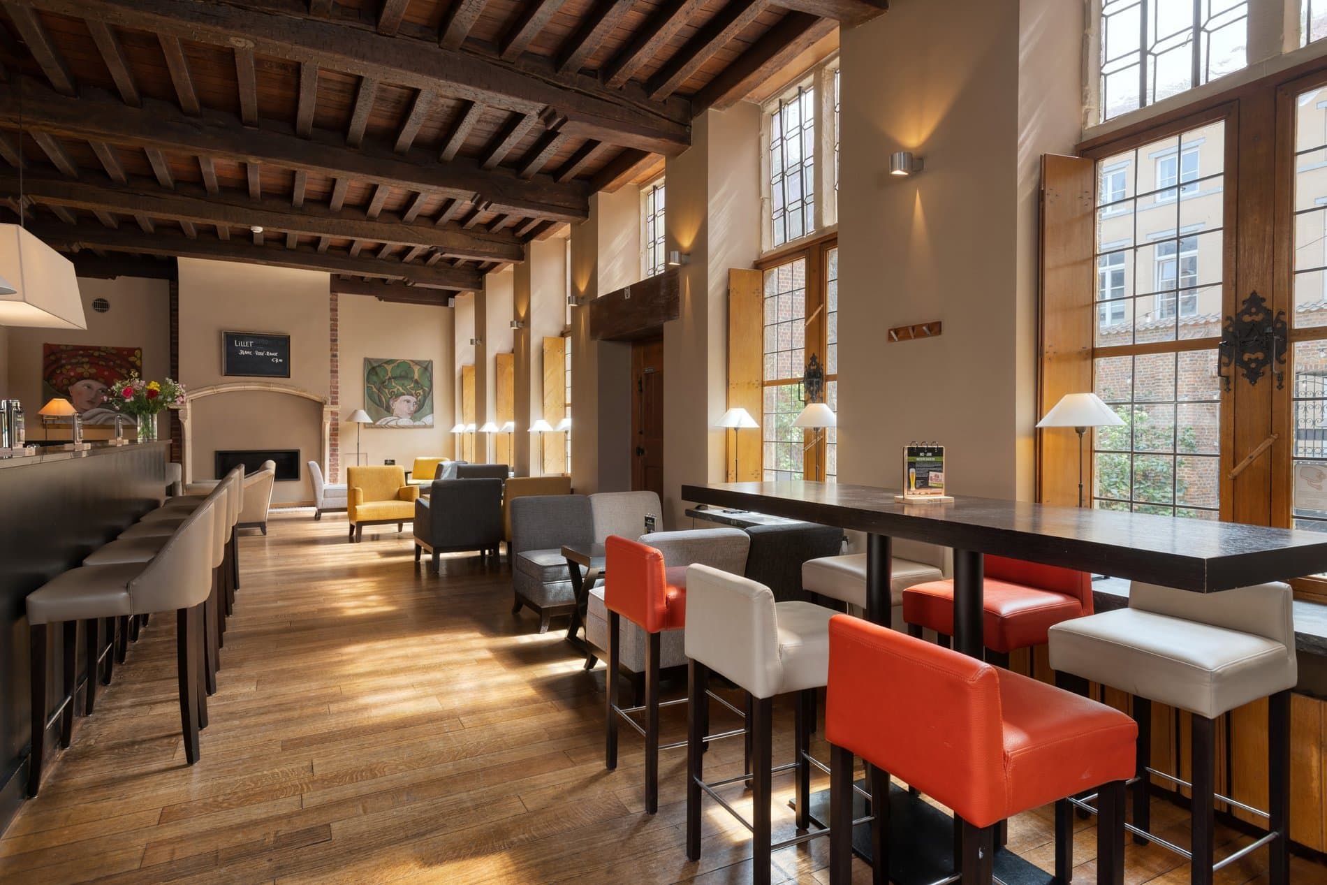 Hotel lobby with reception desk, lounge seating, bar counter, and fireplace.