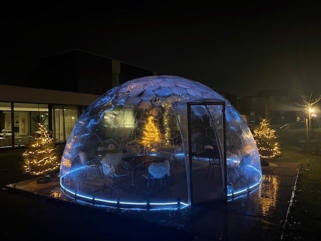 Illuminated geodesic dome structure at night with neon blue lighting